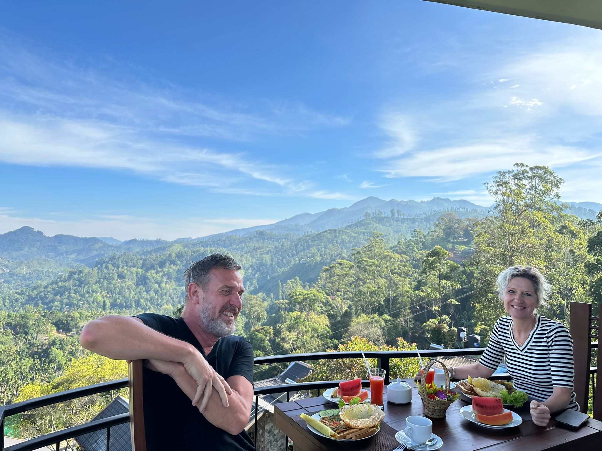 A couple dining at a table with a scenic mountain view.