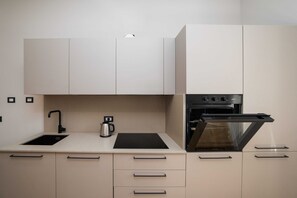 Eine moderne Küche mit eingebautem Backofen, Wasserkocher und Spüle.