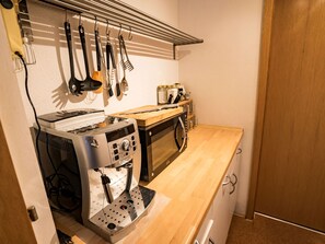 A compact kitchen with a microwave, toaster, and kettle. - Ferienwohnungen Felder, (Splügen), by Interhome (Splügen)