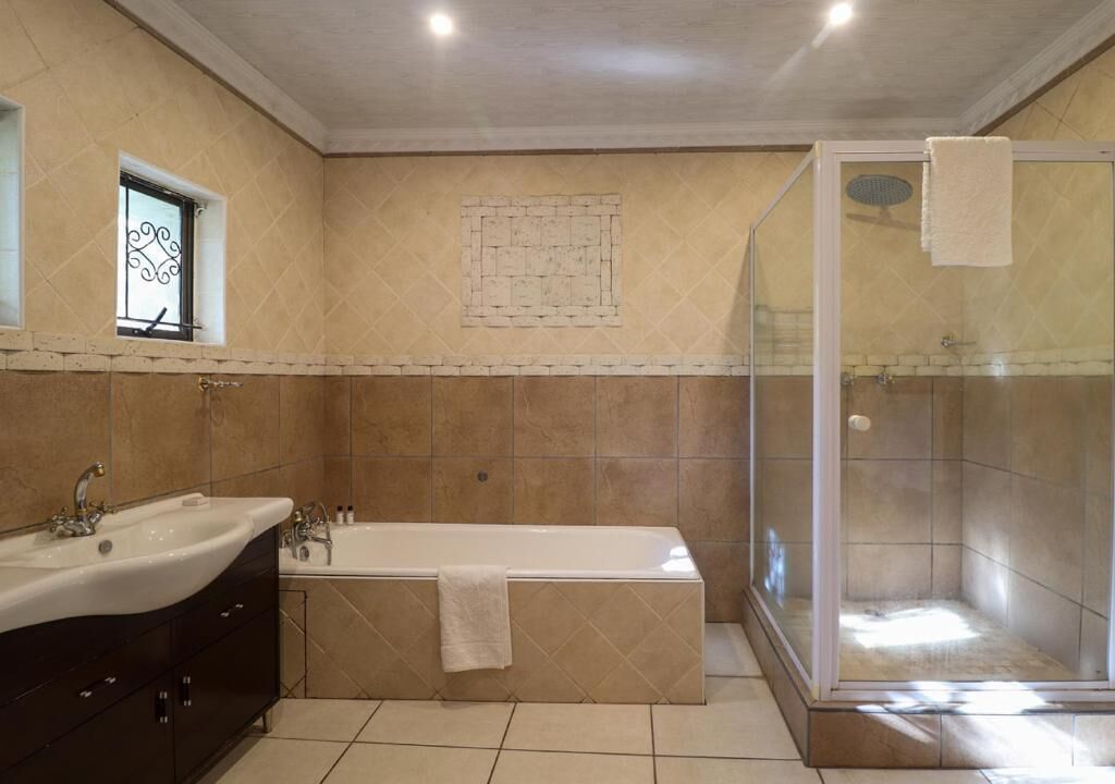 A bathroom with a bathtub, a shower, and a vanity with a sink.