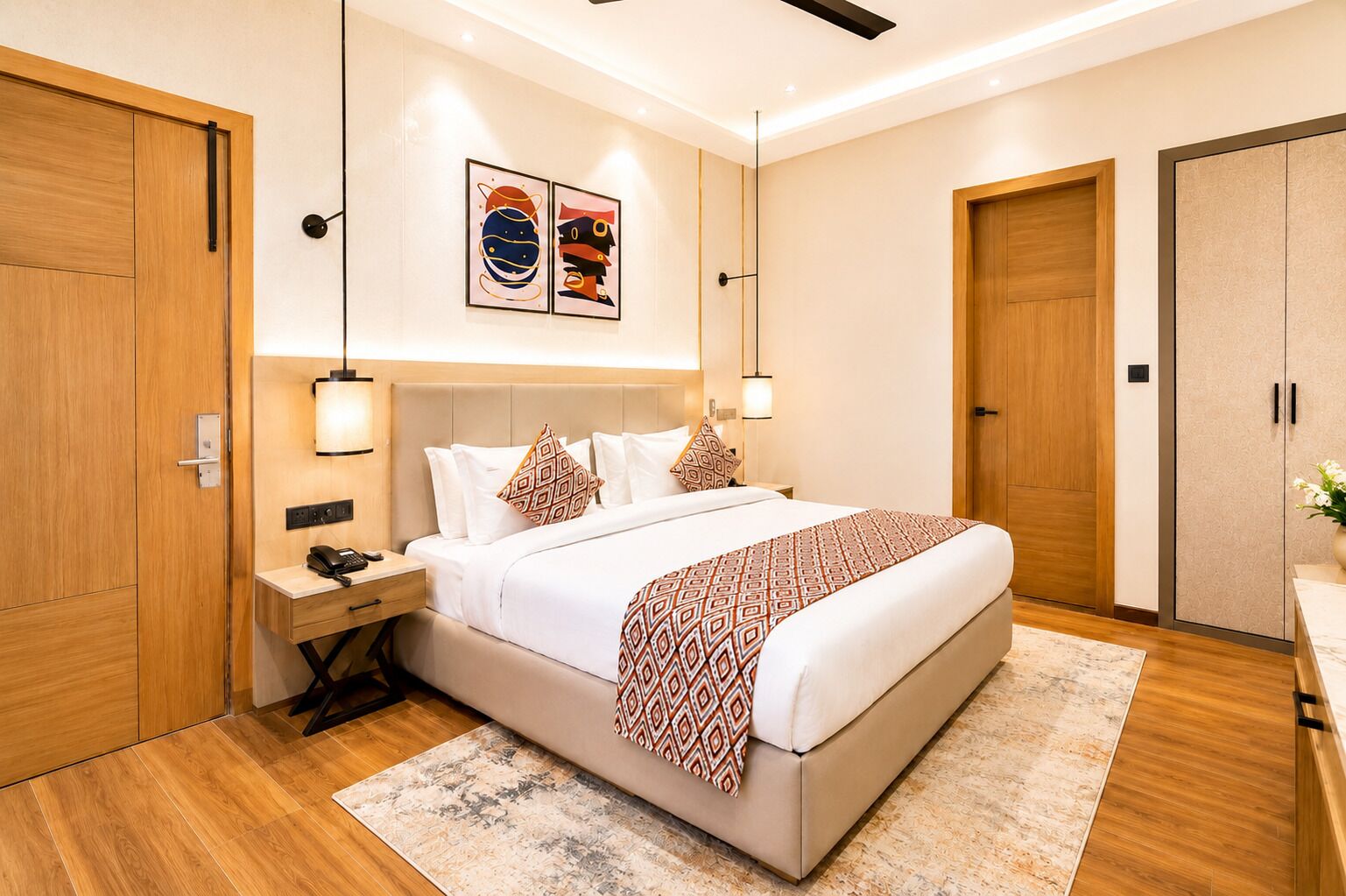 Een moderne hotelkamer met een groot bed, nachtkastjes en een kunstwerk aan de muur.