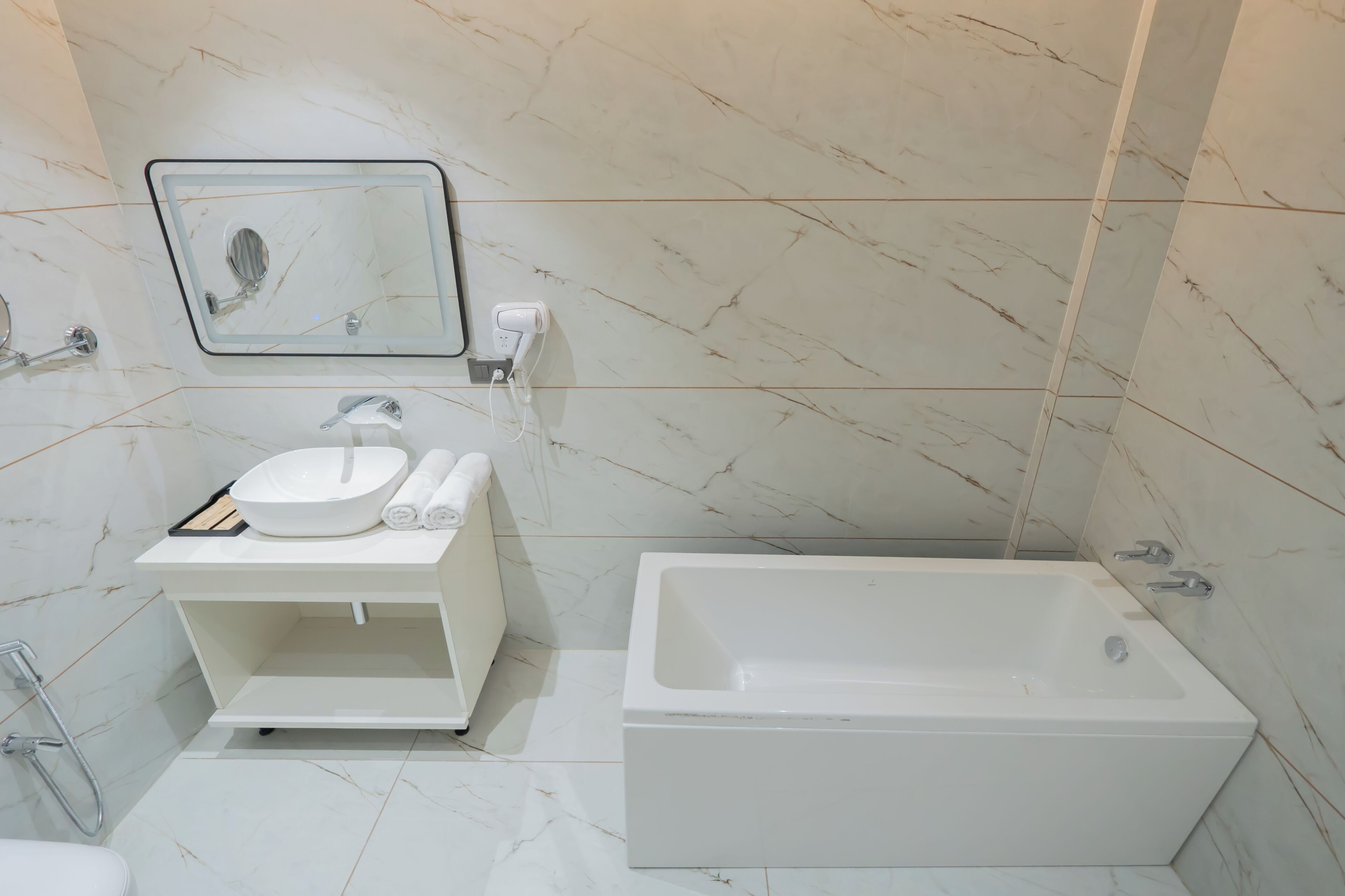 A modern bathroom with a white sink, mirror, and a standalone bathtub.