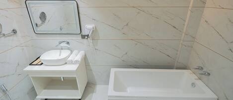 A modern bathroom with a white sink, mirror, and a standalone bathtub.
