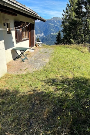 A house with a paved patio and a view of mountains.
