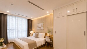 Een hotelkamer met een bed, nachtkastje, bureau, stoel, kledingkast en een raam met gordijnen.