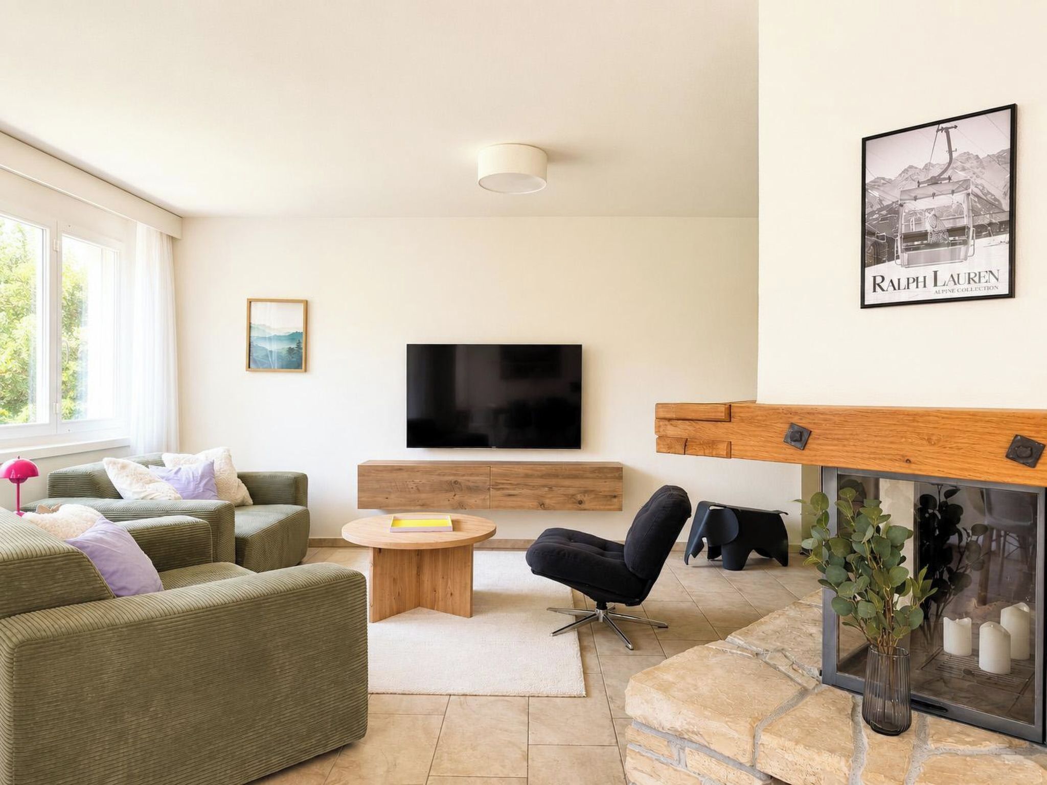 Una sala moderna con sofá, mesa de centro, televisor y chimenea.