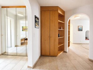 A spacious room with a wooden wardrobe, a bed, and a hallway leading to another room. - Montefiori Jama Stay Appartement/Fewo, Toilette und Bad/Dusche getrennt, 6-Bettw by Interhome (Arosa)