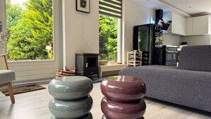 Una sala moderna con sofá, chimenea y vistas al exterior.