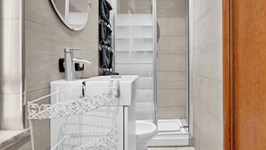 Un baño moderno con ducha, inodoro y lavabo.