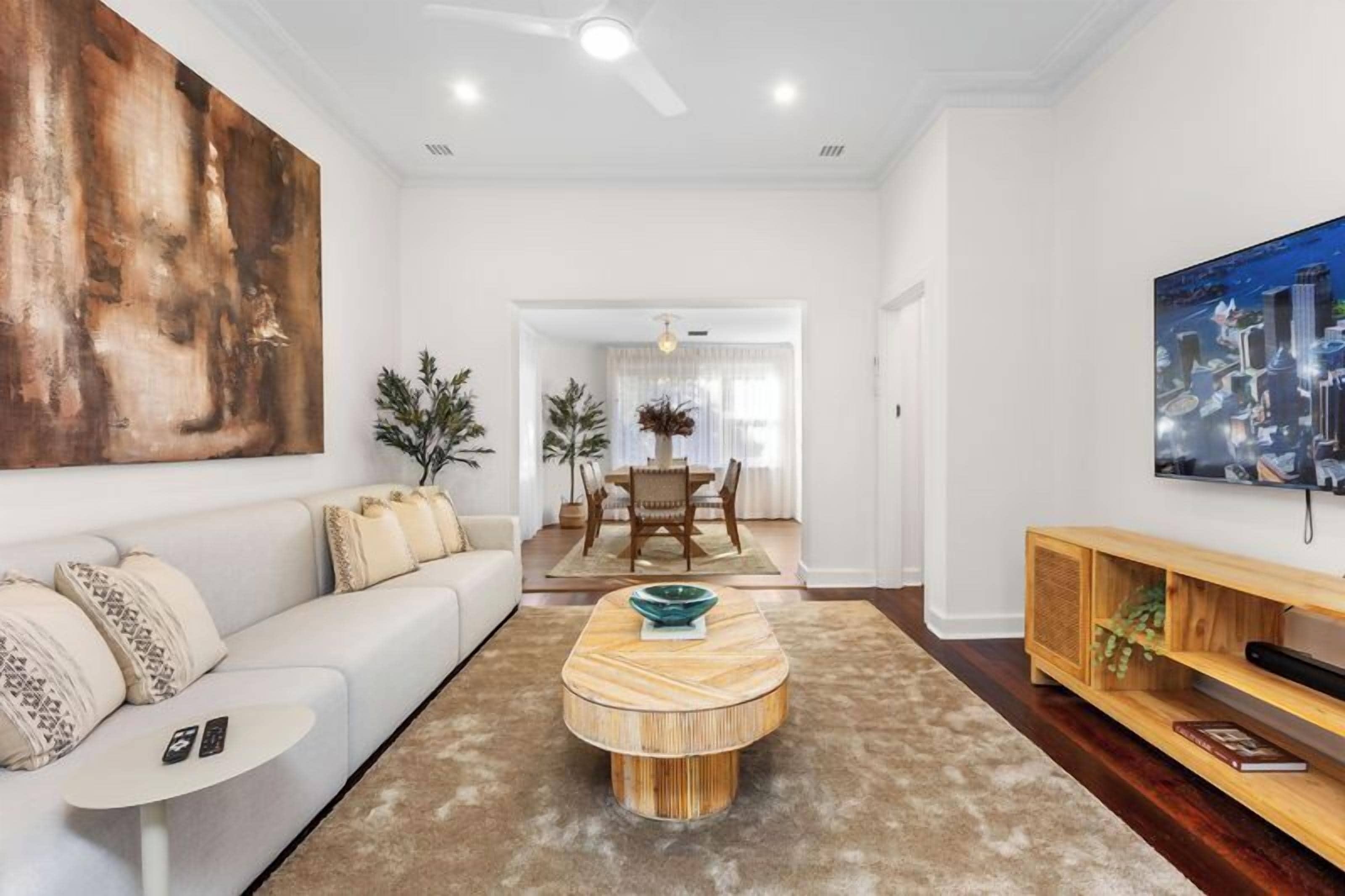 A modern living room with a sofa, coffee table, and artwork on the walls.