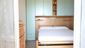 A bedroom with a bed, a wardrobe, and a chest of drawers. -  M472 - Marcelli, comfortable terraced house near the sea (Marcelli)