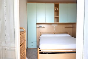 Une chambre à coucher avec un lit, une armoire et une commode.