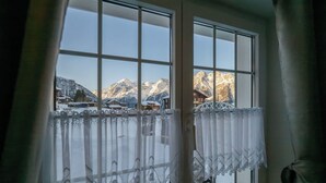 A window with a view of snow-covered mountains and a chalet. - Edelweiss, (Grächen), 5051 by Interhome (Grächen)