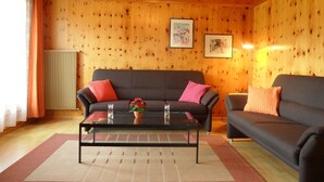 A cozy living room with a sofa, a coffee table, and a radiator. - Chalet Matten, (Grächen), by Interhome (Grächen)