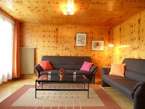 Ein gemütliches Wohnzimmer mit einer Couch, einem Couchtisch und einer Heizung.