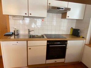 A compact kitchen with a dishwasher, oven, sink, and a built-in stove. - Alicia, (Grächen), 1901 by Interhome (Grächen)
