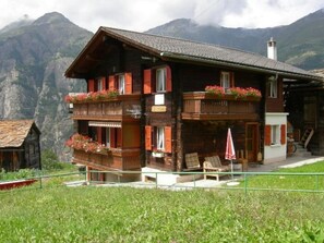 A chalet-style building with a balcony, a staircase, and a view of mountains. - Sunnuschy, (Grächen), 1056 by Interhome (Grächen)