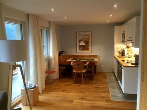 A compact kitchen with a dining area, wooden flooring, and a view of the outdoors. - Anita, (Grächen), 1055 by Interhome (Grächen)