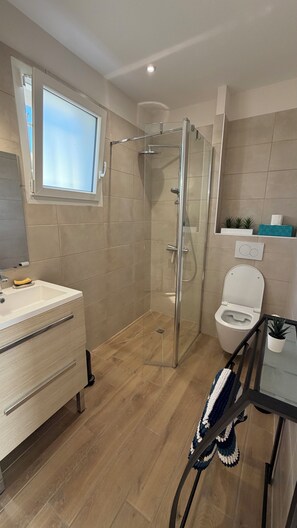 A modern bathroom with a glass-enclosed shower, a toilet, and a sink with a mirror. - BEACH HOUSE, Vensac Océan, just outside Montalivet: a cozy little getaway for two! (Vensac)