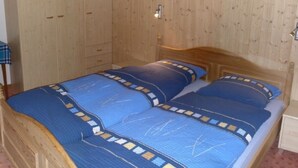 A wooden-paneled room with a bed, a nightstand, and a wardrobe. - Chalet Matten, (Grächen), by Interhome (Grächen)