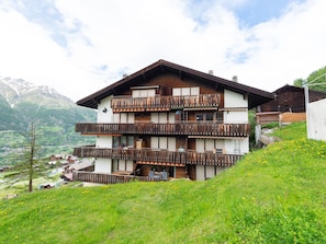 A multi-story chalet with balconies, set in a mountainous area with a view of the valley below. - Castello, (Grächen), 1028 by Interhome (Grächen)