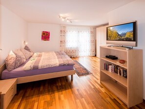 A modern bedroom with a bed, a TV, and a bookshelf. - Castello, (Grächen), 1028 by Interhome (Grächen)