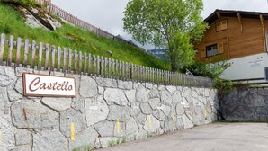 Een stenen muur met een bord waarop 'Castello' staat en een houten hek.