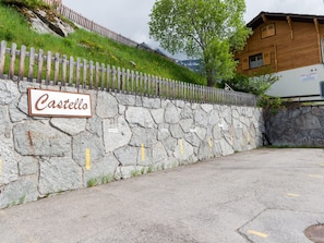 Eine Steinmauer mit einem Schild, auf dem 'Castello' steht, und ein Holzzaun.
