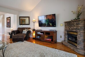 A living room with a fireplace, a television, and a sofa.