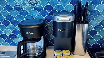 A coffee maker, a Keurig, and coffee pods on a kitchen counter.