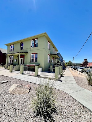 A two-story building with a porch and a fenced yard. - Luxury Downtown Studio • 2 Blocks to the Square (Prescott)