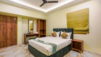 A bedroom with a bed, a wardrobe, a vanity, a ceiling fan, and a large window with a curtain.