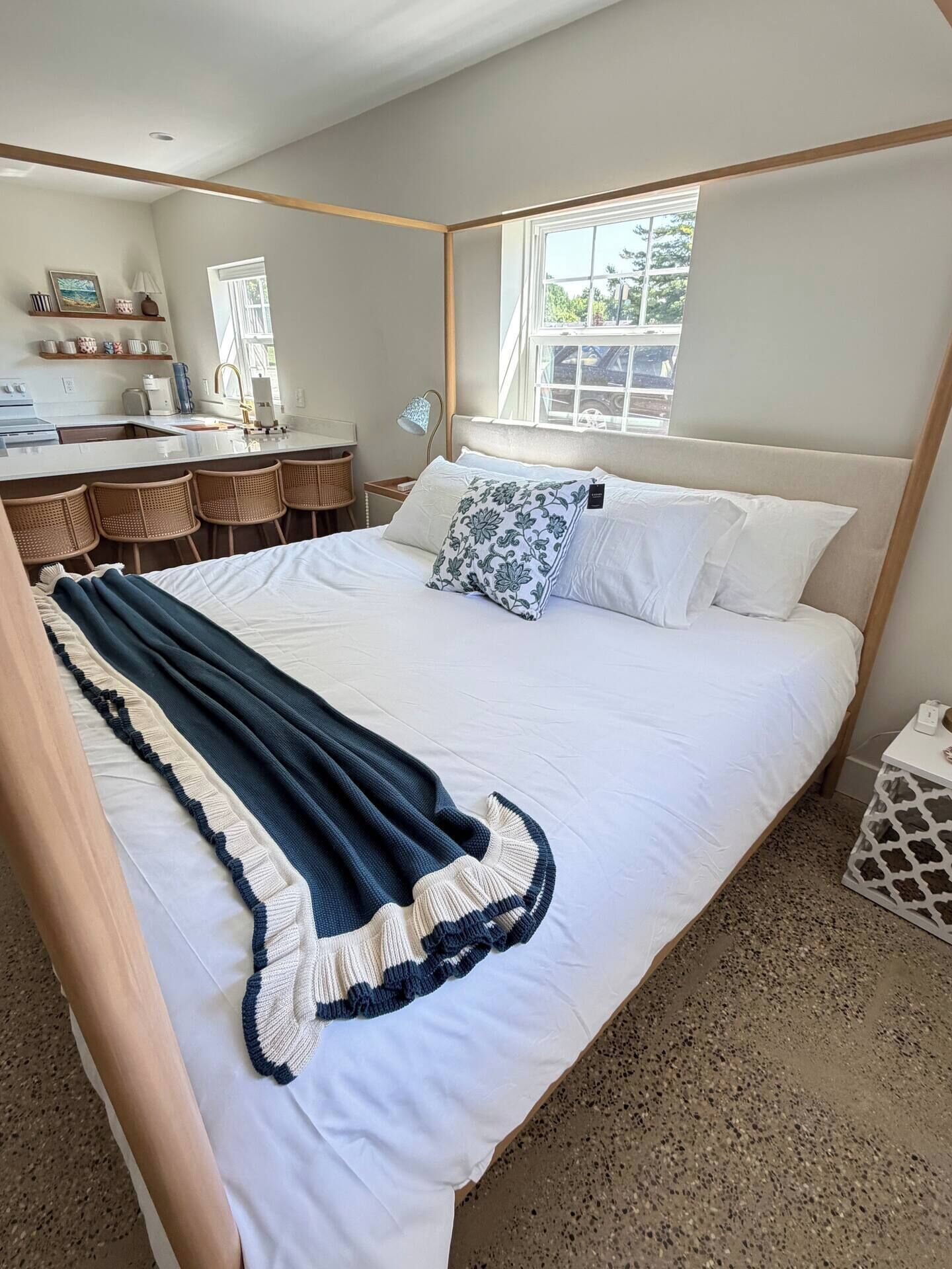 A bedroom with a bed, a window, a desk, and a chair.
