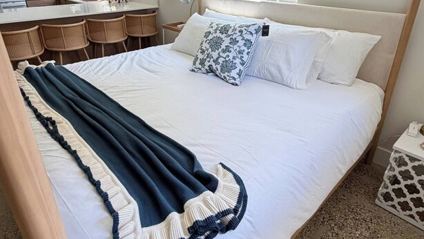 Een slaapkamer met een bed, een raam, een bureau en een stoel.
