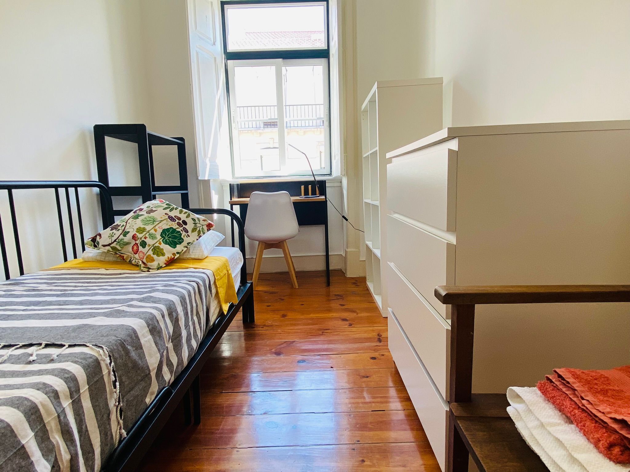 Une chambre à coucher comprenant un lit, un bureau, une chaise et une armoire.