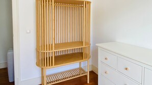 Una habitación con un aparador blanco, una estantería de madera y una puerta.