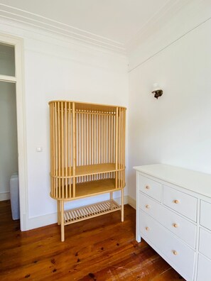 A room with a white dresser, a wooden shelf unit, and a door. - Perfect Flat in the Center (Lisboa)