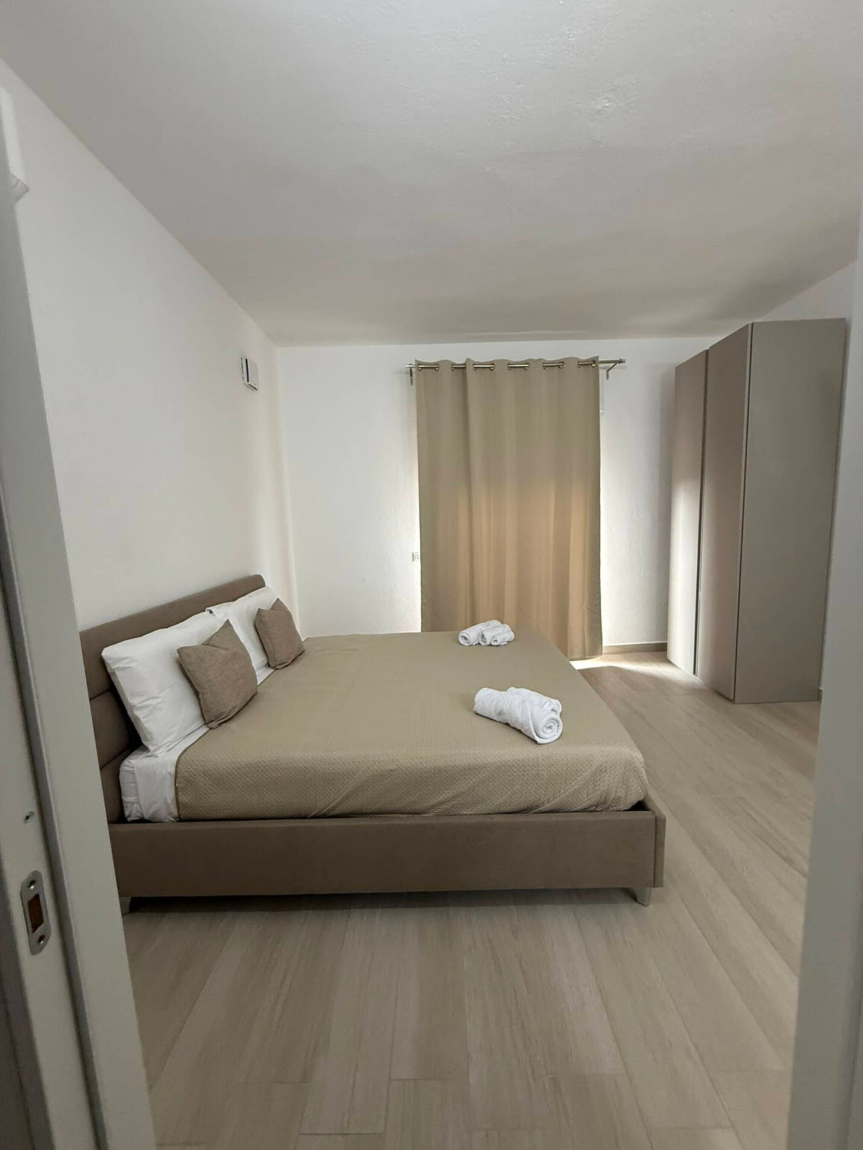 Ein Schlafzimmer mit einem Bett, einem Kleiderschrank und einem Vorhang.