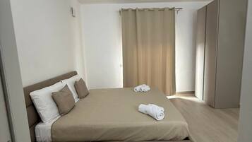 Ein Schlafzimmer mit einem Bett, einem Kleiderschrank und einem Vorhang.