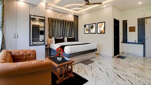 Ein modernes Hotelzimmer mit Bett, Sitzecke, Schreibtisch und Badezimmer.