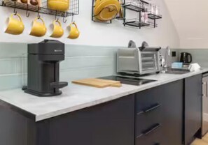 A kitchen with a coffee maker, toaster, and a cutting board on the counter. - Central 1-bed Apartment, Sleeps 3 Near Parking (Bournemouth)