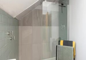 A shower with a glass door, a towel rack, and a stack of books. - Central 1-bed Apartment, Sleeps 3 Near Parking (Bournemouth)