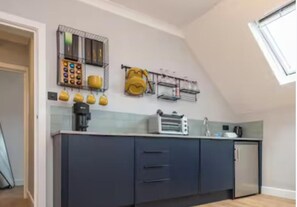 A kitchen with a built-in oven, a coffee maker, and a toaster. There are cabinets and a window above the sink. - Central 1-bed Apartment, Sleeps 3 Near Parking (Bournemouth)