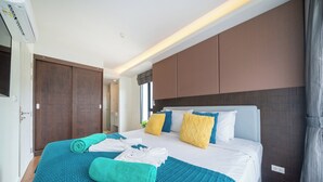 A hotel room with a bed, a bathroom, and a door. - Best for Digital Nomad-1 BR Apt close to Surin Beach (Tambon Choeng Thale)