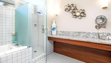 A modern bathroom with a shower, a bathtub, a vanity with a mirror, and a decorative wall piece.