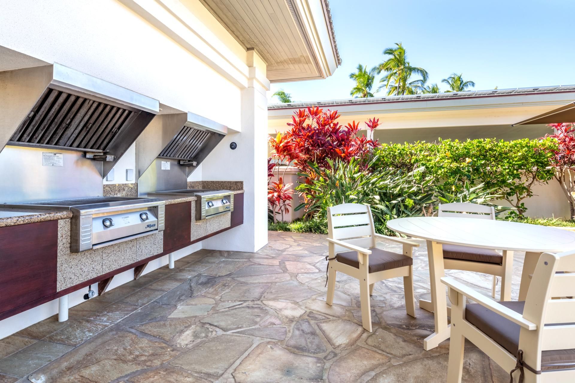 Une cuisine extérieure équipée d’un barbecue, d’une table et de chaises.