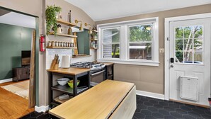 Una cucina moderna con piano cottura integrato, mensole in legno e una finestra che offre vista sull'esterno.