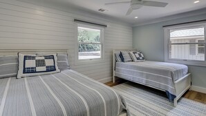 A bedroom with two beds, a ceiling fan, and windows. - New Listing! Luxury Updated 4 BR 3 BA Golf View Near the Beach Pool Sea Pines (Hilton Head Island)