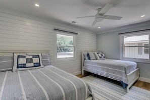 A bedroom with two beds, a ceiling fan, and windows. - New Listing! Luxury Updated 4 BR 3 BA Golf View Near the Beach Pool Sea Pines (Hilton Head Island)