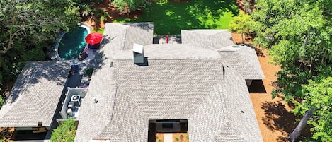 A rooftop with a swimming pool, outdoor seating, and a garden area.